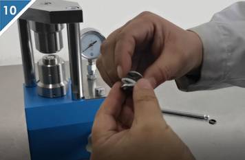 10. Estrarre la batteria a bottone separata dalla sigillatrice.